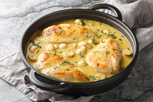 Chicken and mushrooms in a creamy lemon dijon sauce closeup in t